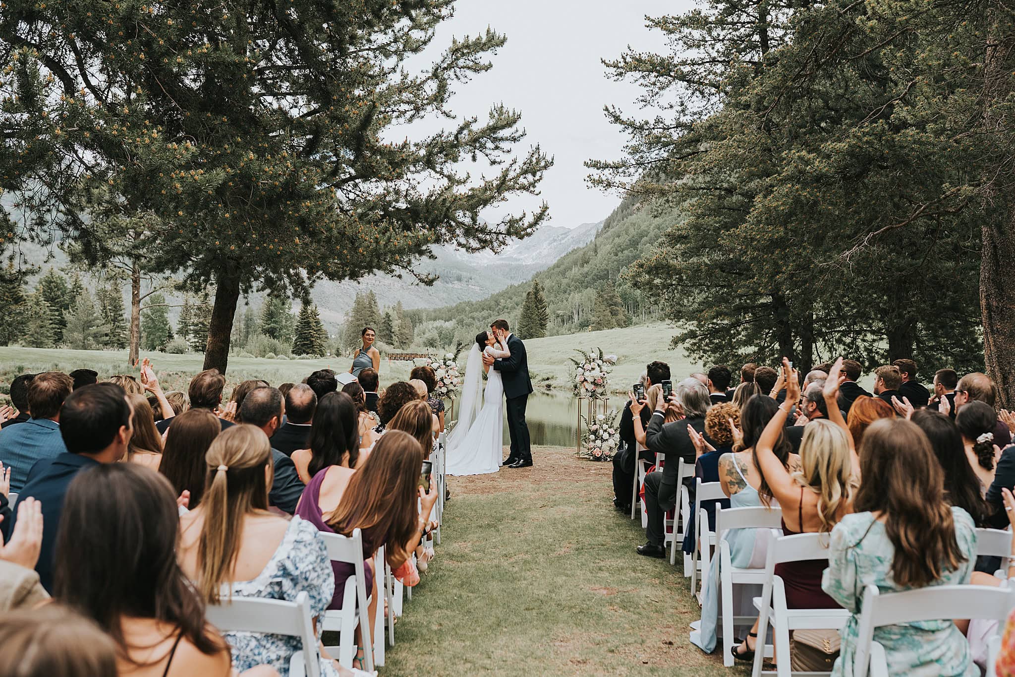 bride and groom kiss during wedding ceremony at vail golf and nordic center
